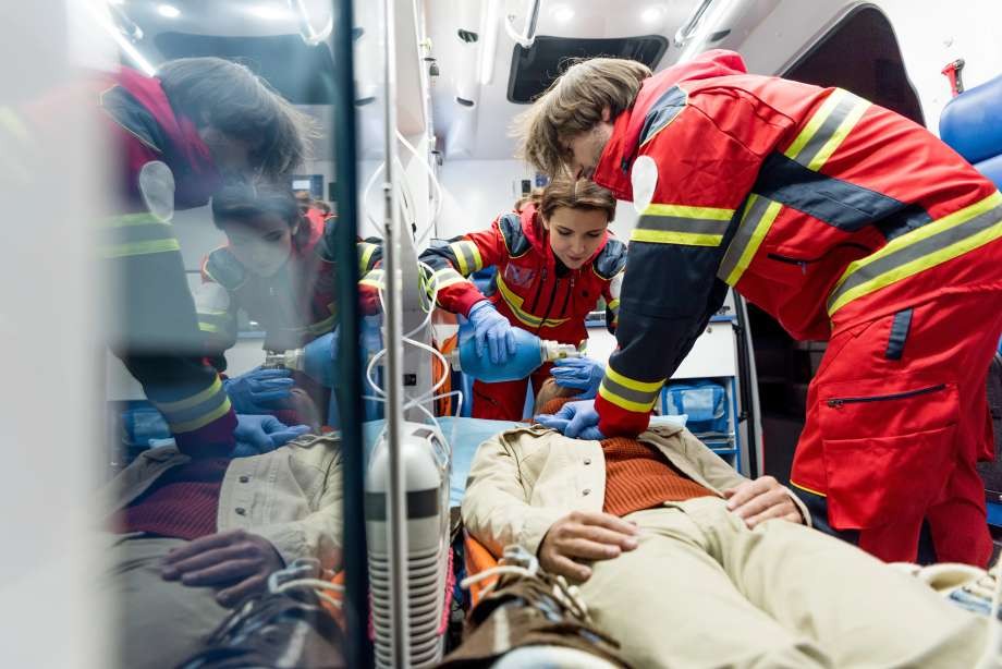 Emergency medical technicians provide urgent care to a patient inside an ambulance.