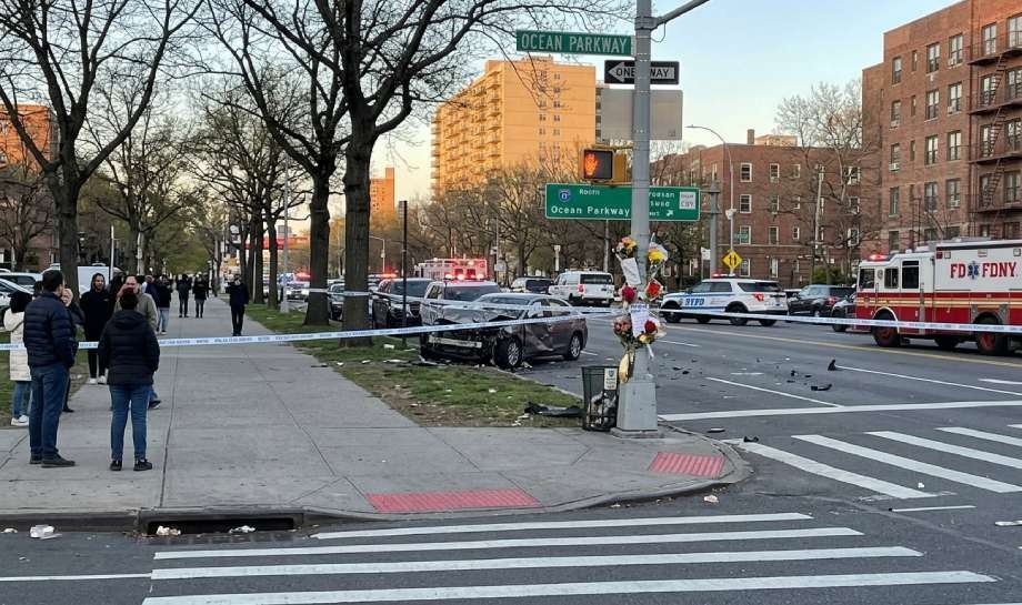 A car crash scene at an intersection with police tape, emergency vehicles, and a damaged car on the grass near Ocean Parkway. The Ocean Parkway crash shows perils NYC drivers face daily, with bystanders and debris scattered nearby.