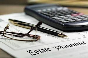 Estate planning document with a calculator, eyeglasses, and a pen.
