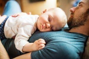 Peaceful baby sleeping on father's chest during a quiet bonding moment.