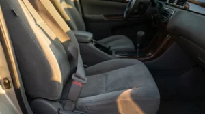 unbuckled seat belt resting on passenger seat inside vehicle interior